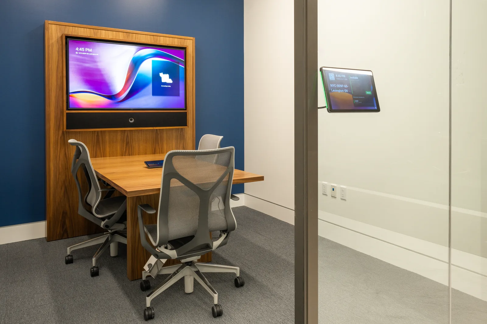 Huddle room with a wall display and scheduling panel